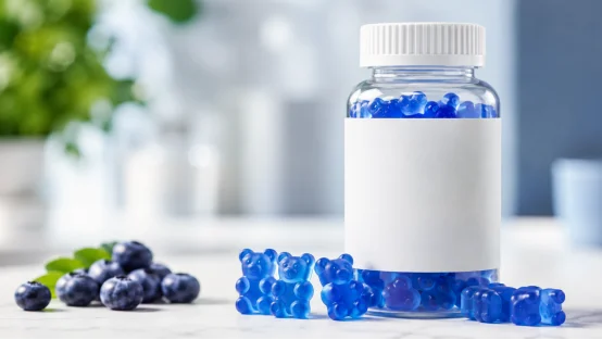 Blue gummy bears bottle with fresh blueberries